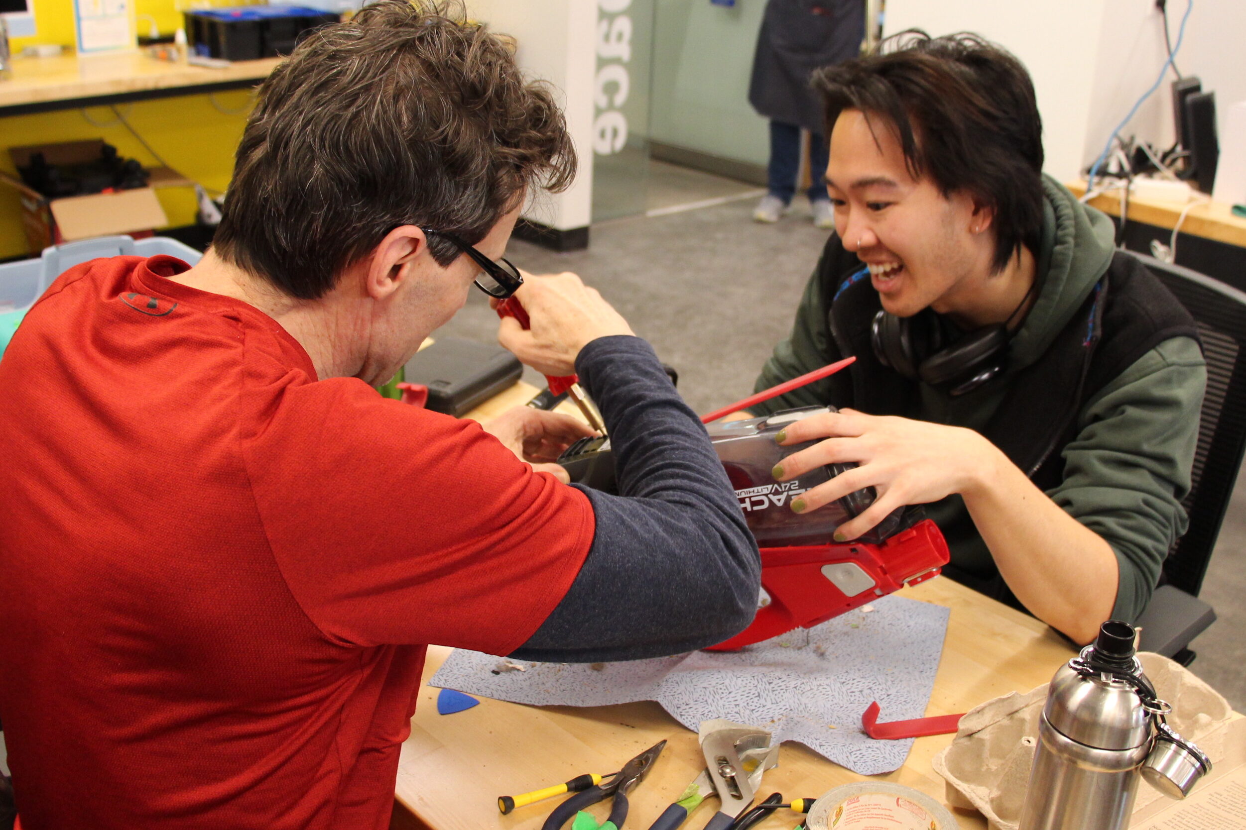 A volunteer helps a student during a Repair Café event